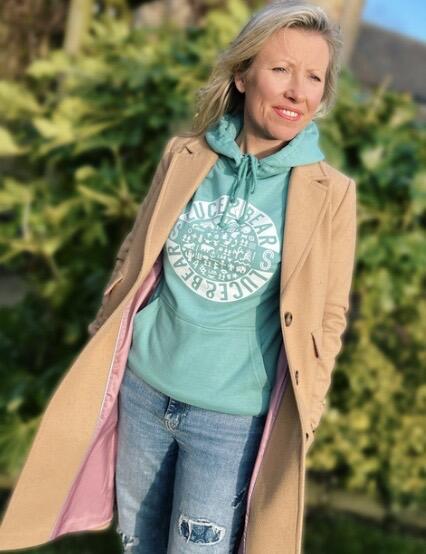 Woman wearing seafoam and rose Healing Hoodies from our womenswear collection