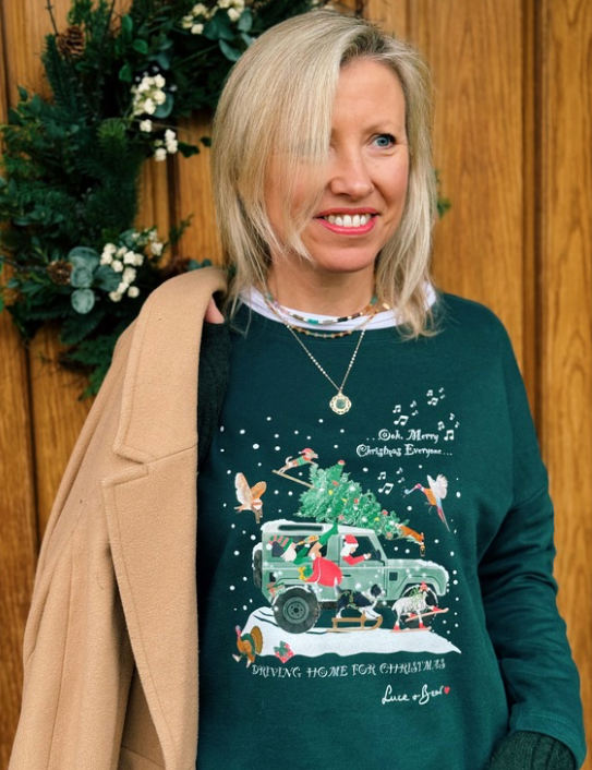 Woman wearing Driving Home for Christmas dark green sweatshirt