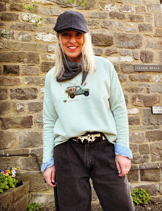 Woman wearing dusty green Enjoy the Ride sweatshirt