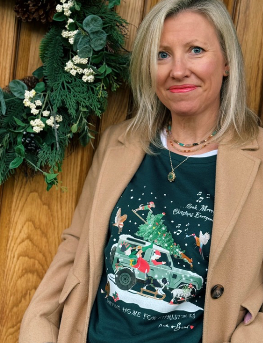 Woman wearing Driving Home for Christmas dark green sweatshirt