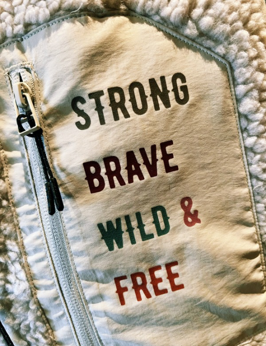 Close up,of Strong, Brave, Wild and Free Pocket on Sherpa Gilet