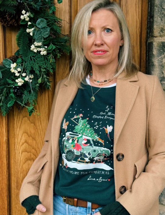 Woman wearing Driving Home for Christmas dark green sweatshirt