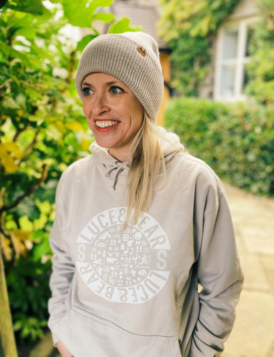Woman wearing Unisex Healing Hoodie in stone with beanie
