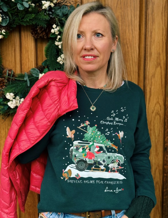 Woman wearing Driving Home for Christmas dark green sweatshirt