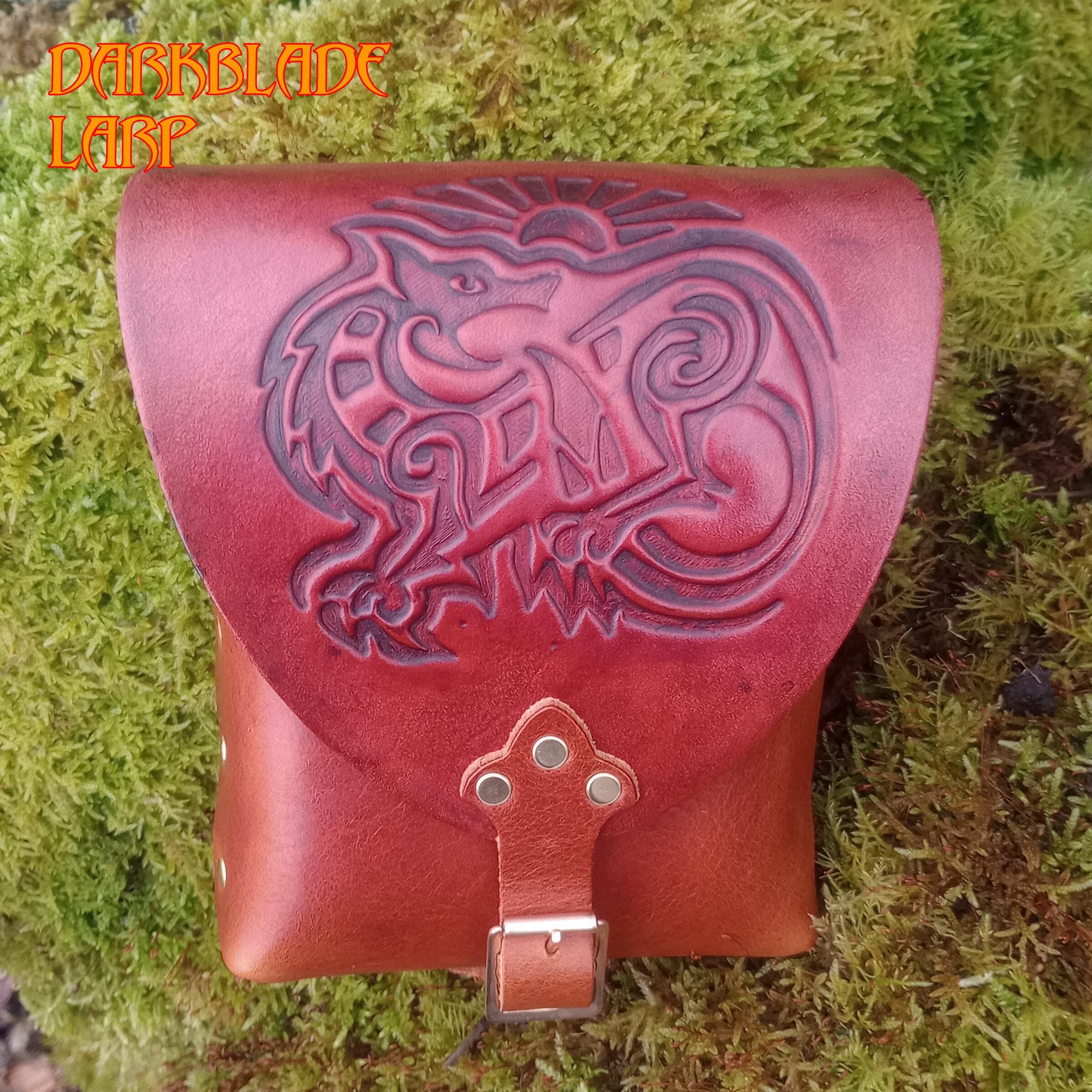 brown leather pouch with an embossed image of a wolf on the flap