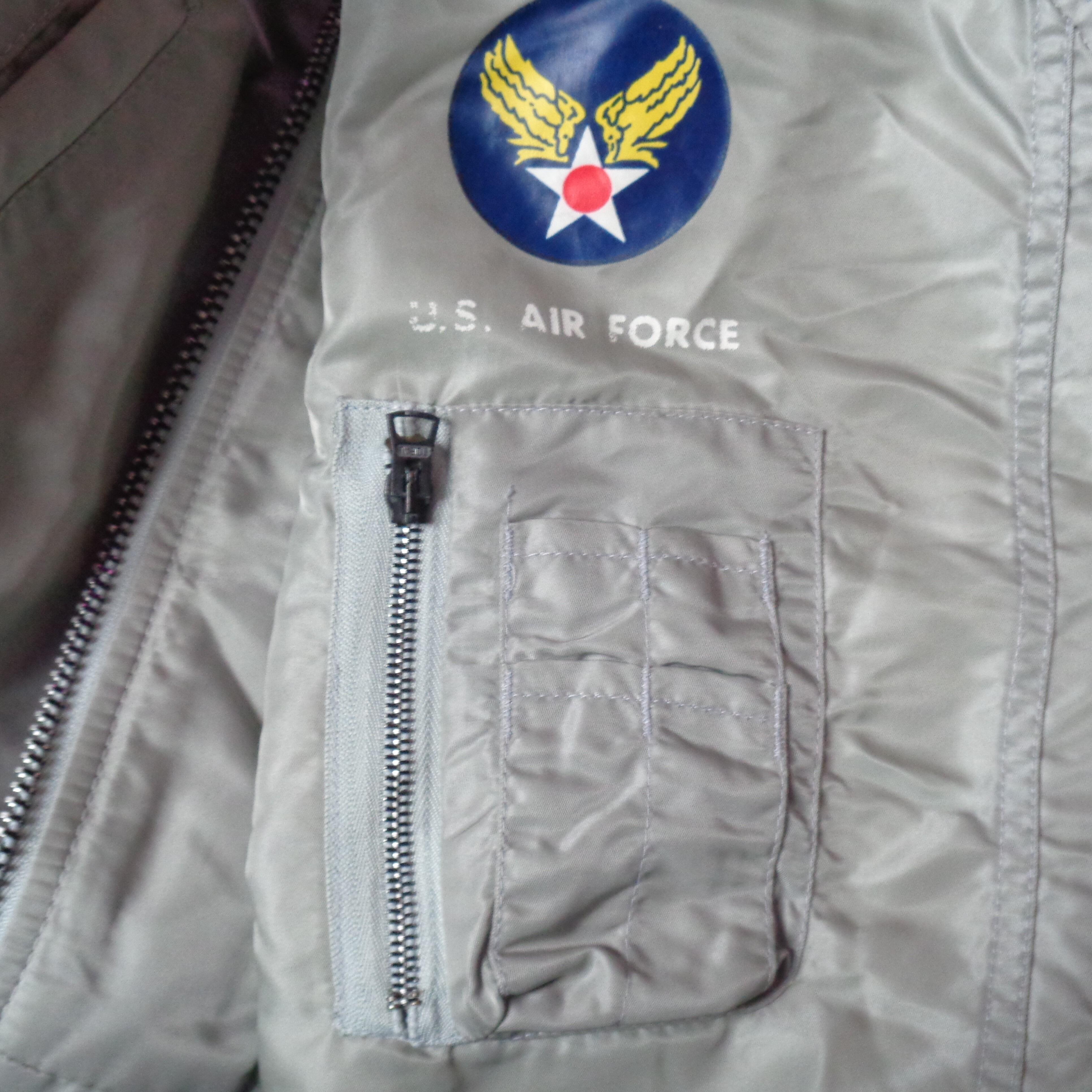 super cool Vintage I Spiewak & Sons Intermediate Flying MA-1 Bomber Reversible JACKET in light grey and black. Zip closure, ribbed collar, cuffs and waistband. Two hand pockets with press stud closure and a zipped pocket on the left arm, fully lined. Can be reversed so also has press stud pockets on the inside whichever way you choose to wear it. 100% nylon Made in USA- pocket detail