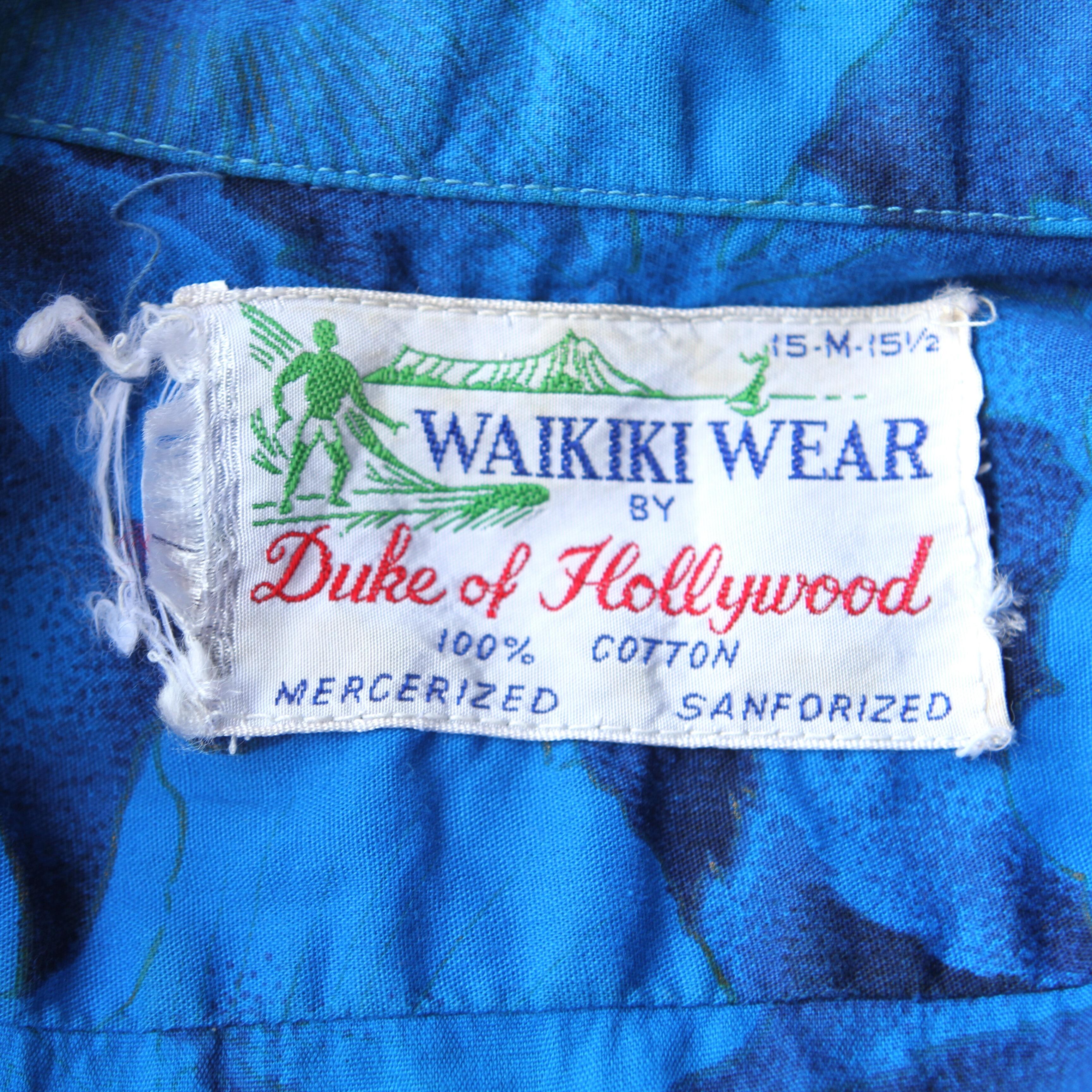 amazing original vintage 60s Waikiki Wear Hawaiian shirt in blue with a floral design in blues black and gold- very cool- label