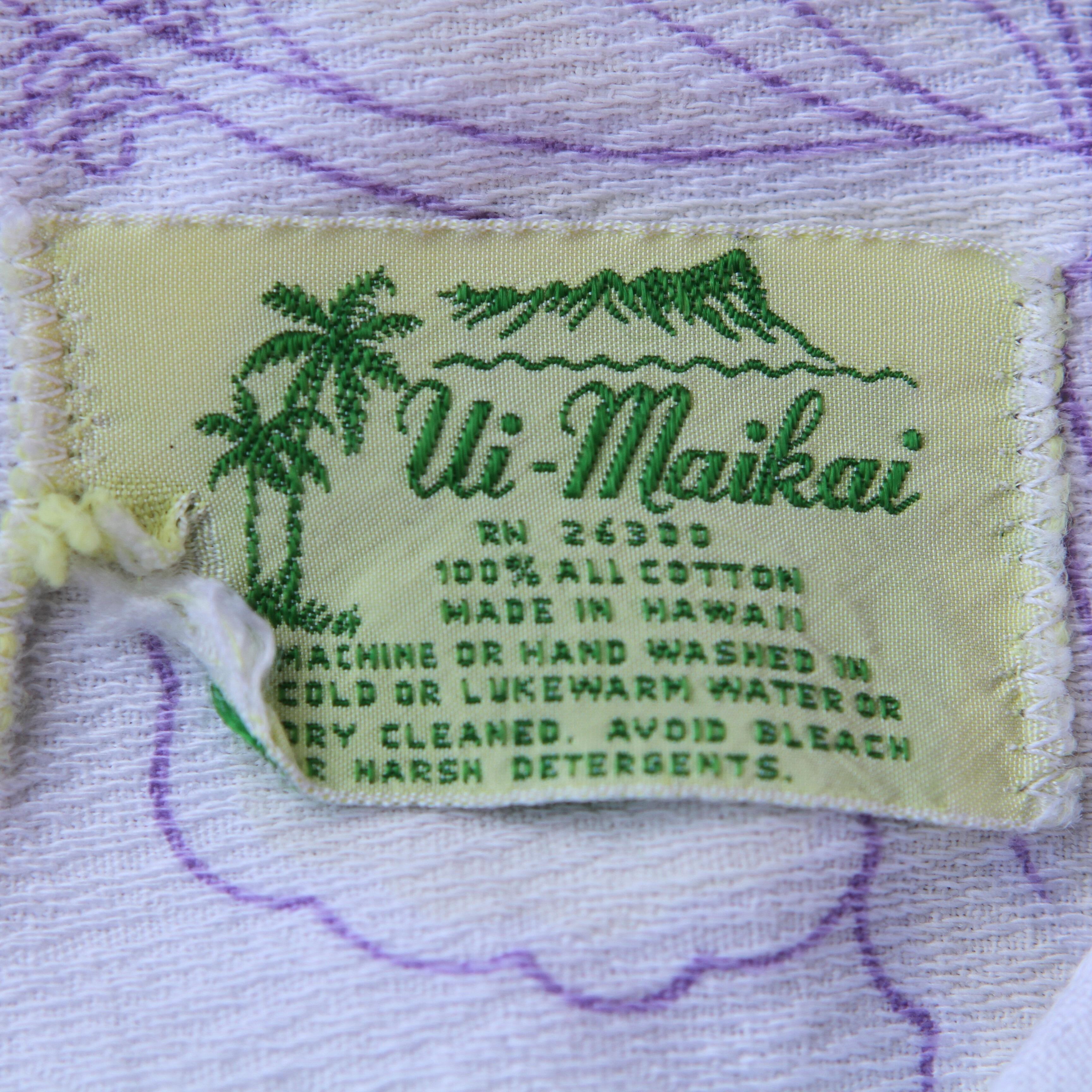 amazing original vintage 60/70s Ui-Maikai Hawaiian shirt featuring bold flowers in purples on a white background -label