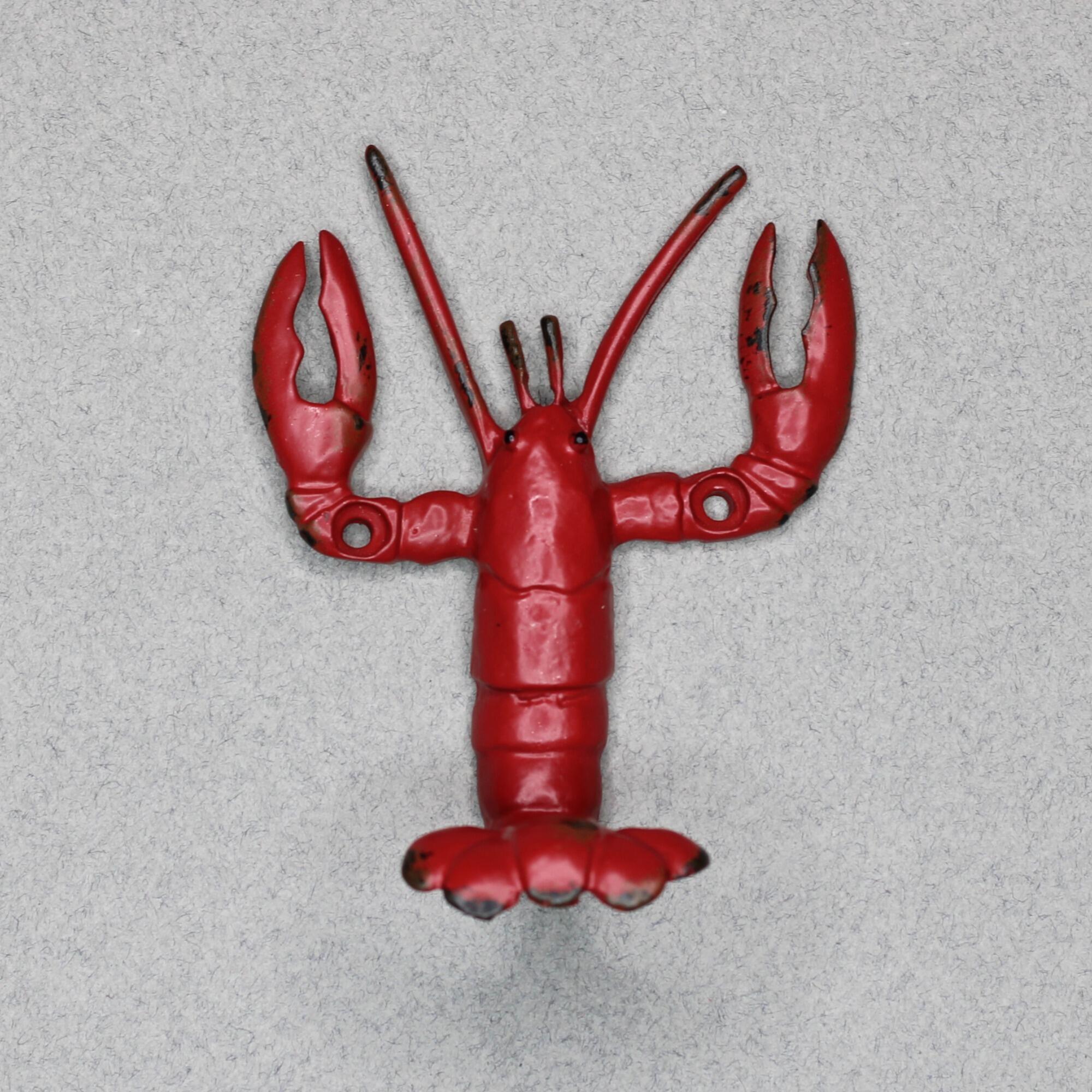 Front-facing view of a red metal lobster wall hook featuring realistic anatomical details, two large claws, and pre-drilled mounting holes in the legs.