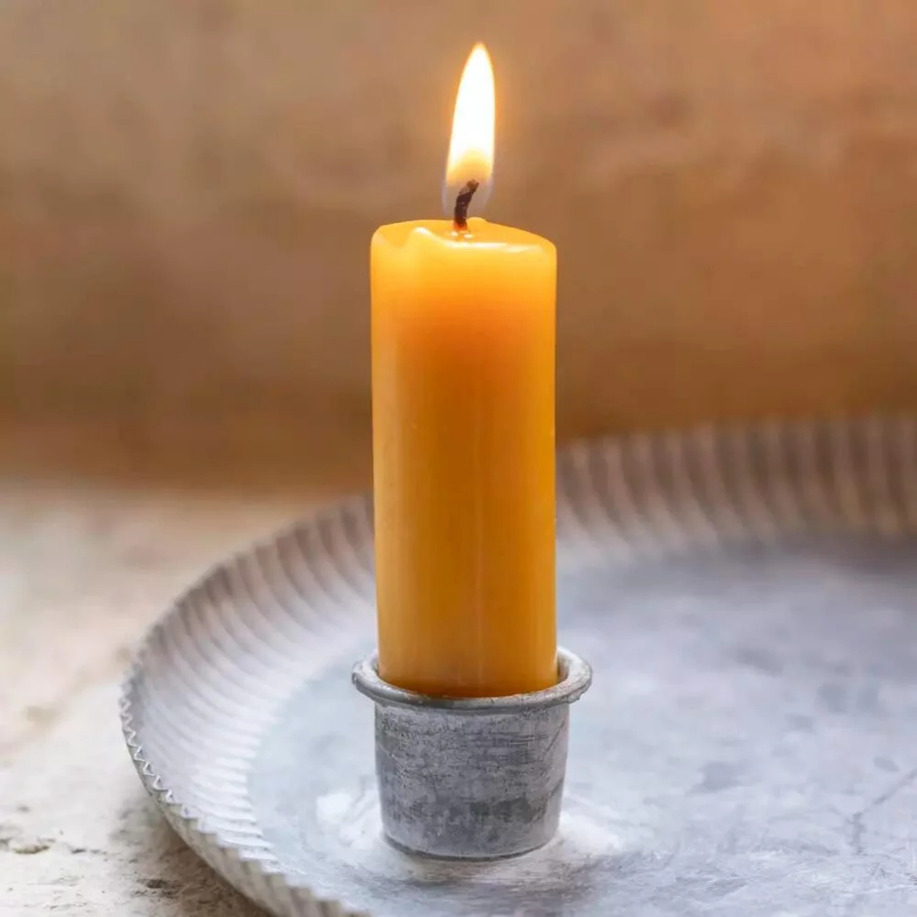Closeup of round fluted zinc candle tray