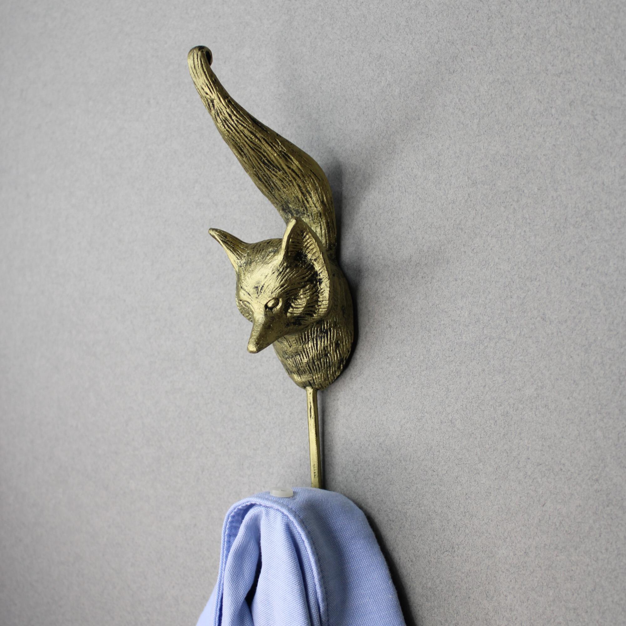 Metal fox-shaped wall hook used to hang shirt