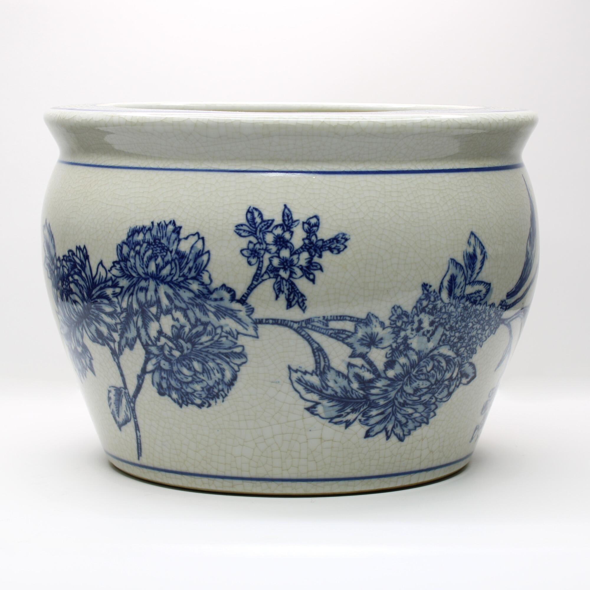 Decorative cachepot combining intricate blue florals with a softly aged finish.
