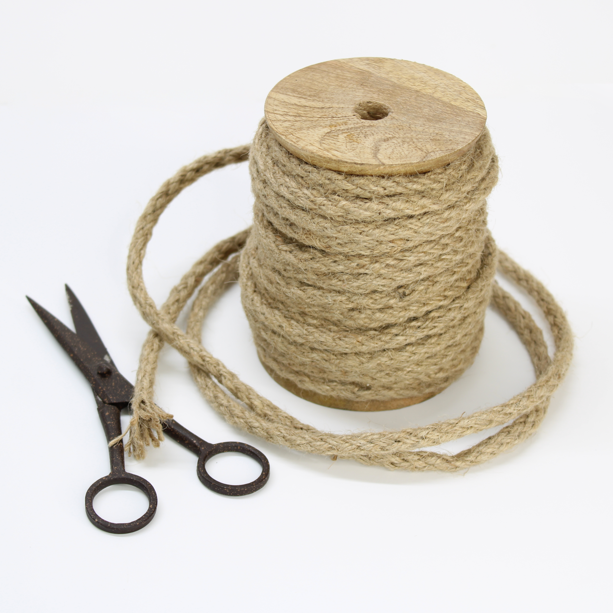 Jute twine spool with vintage scissors on wooden holder for crafts and gardening