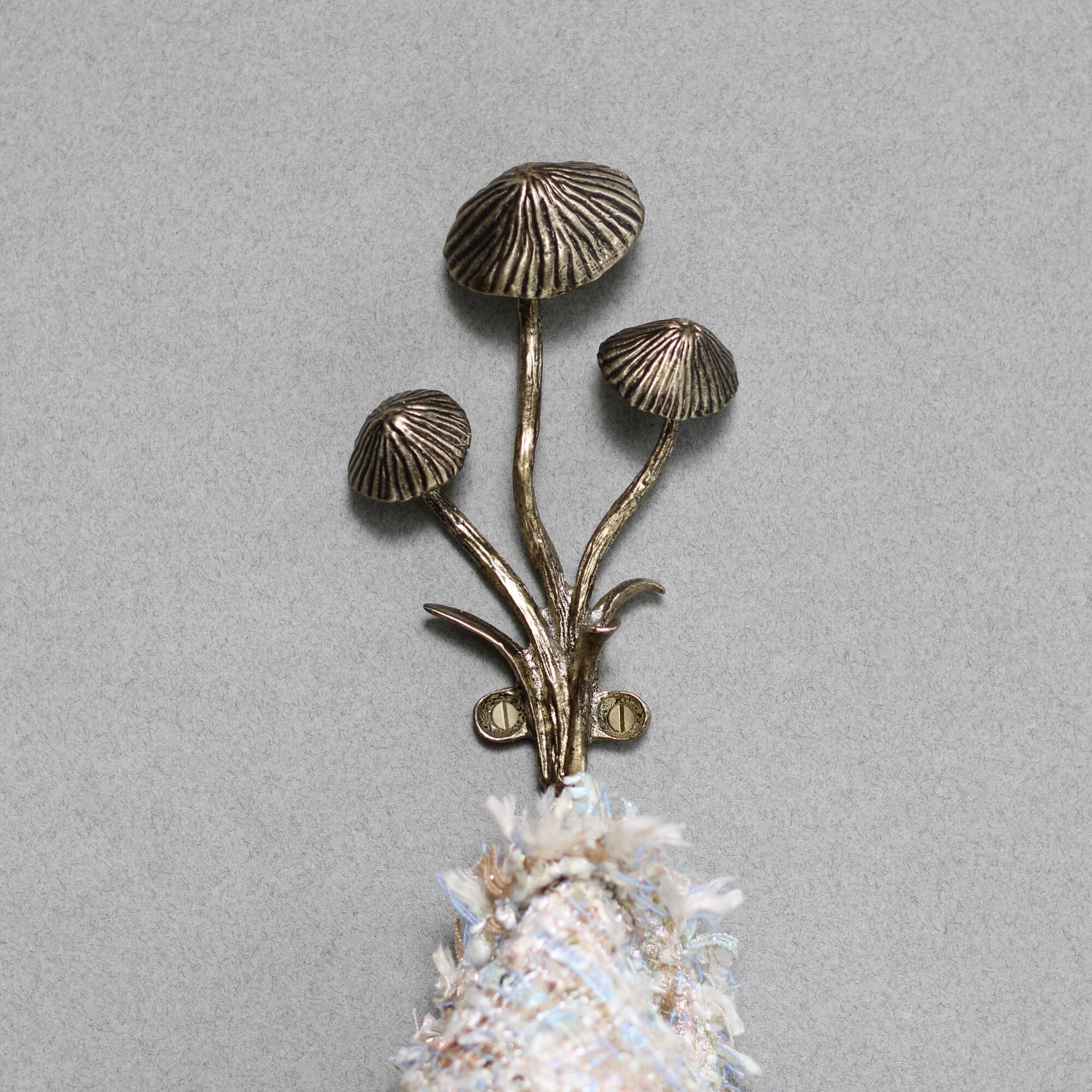 Gold mushroom wall hook holding a jacket