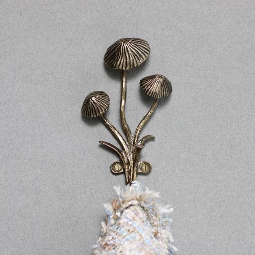 Gold mushroom wall hook holding a jacket