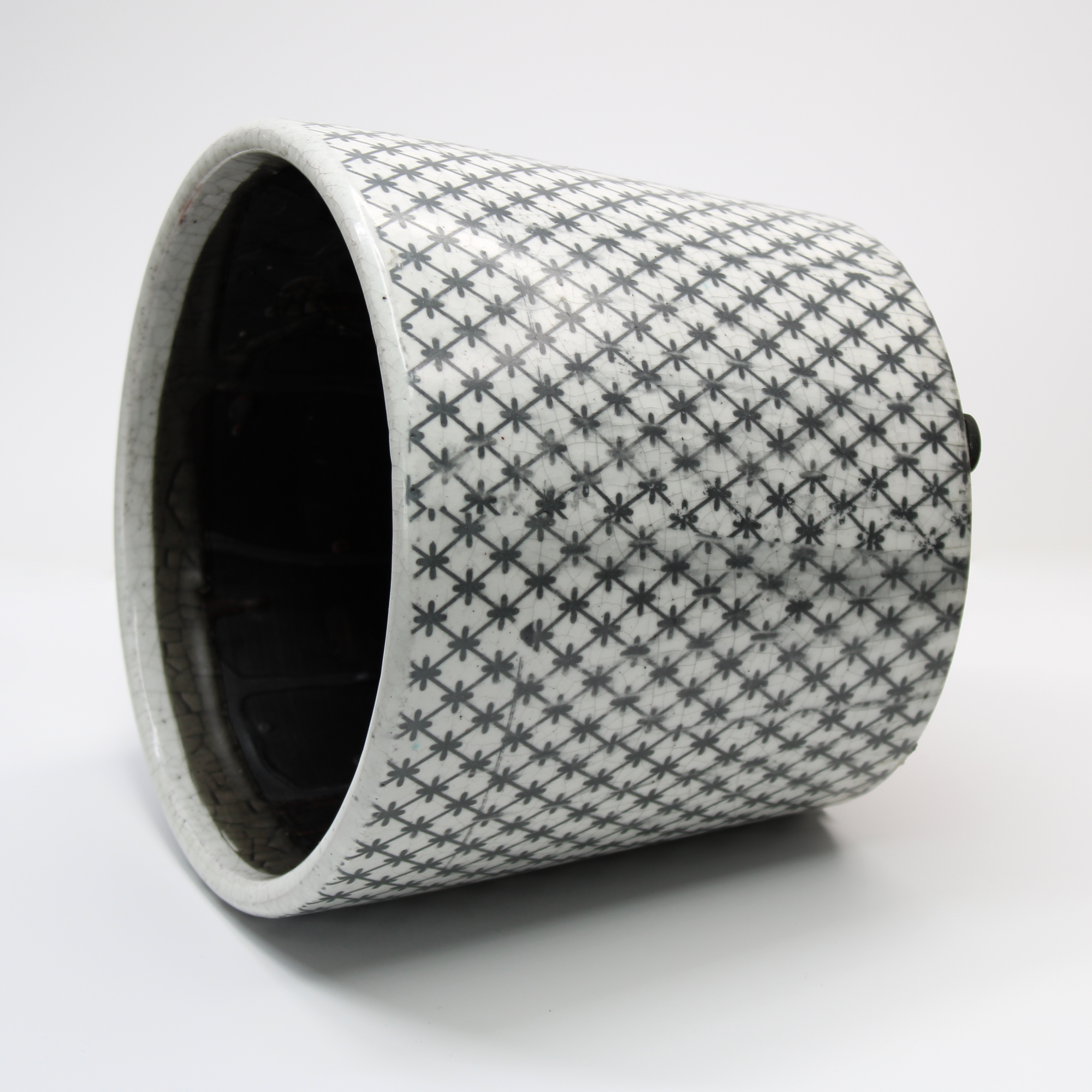 rustic plant pot with a black lattice pattern on a white background