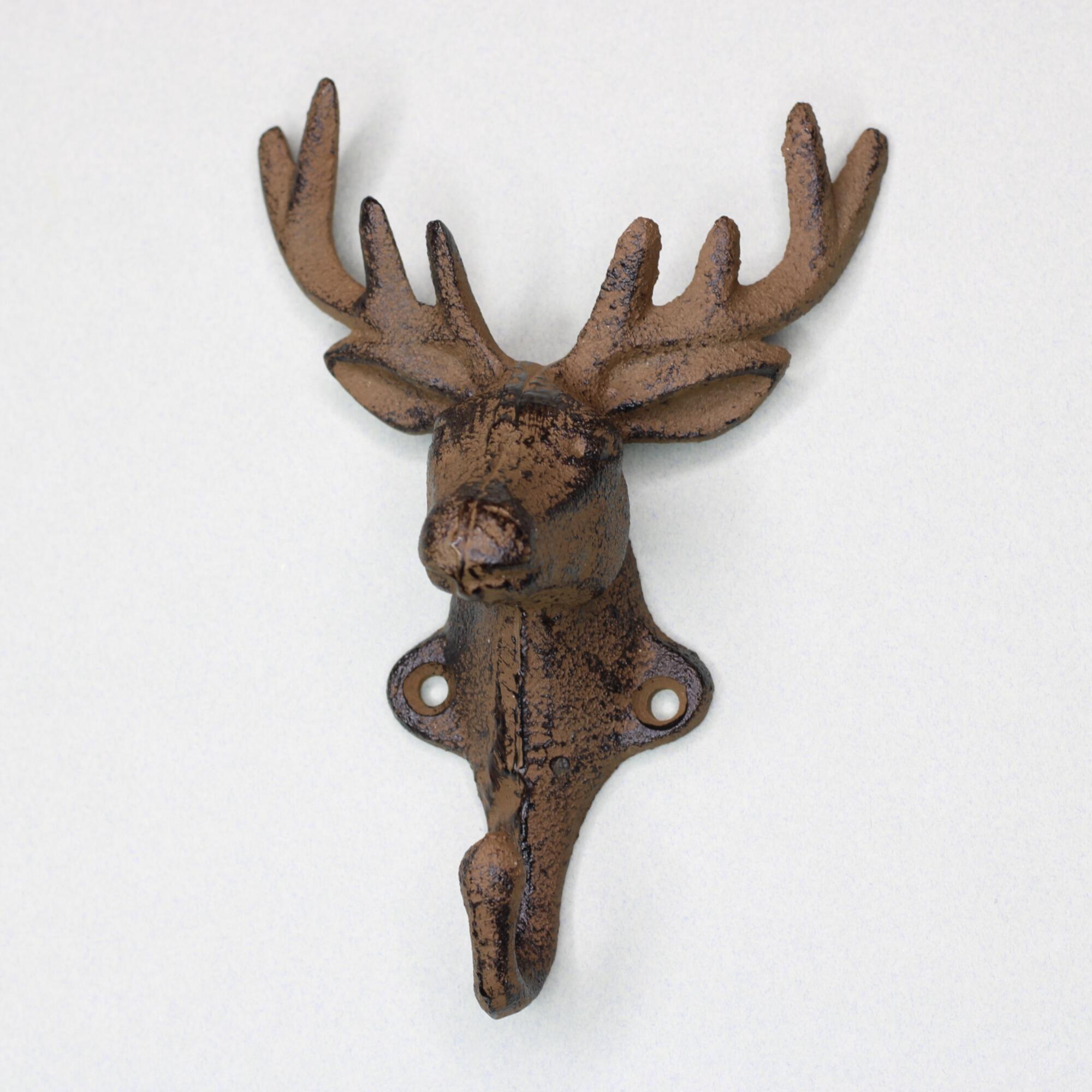 Front view of a rustic cast iron stag head coat hook with detailed antlers and a weathered bronze finish against a neutral background.