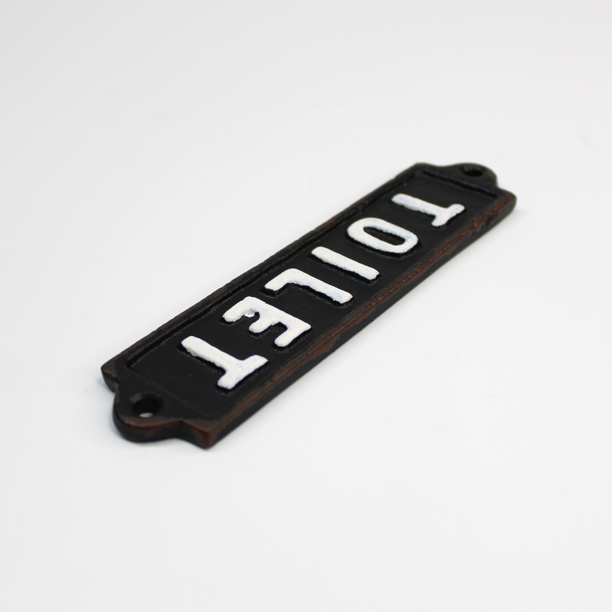 Rustic black and white cast iron toilet door sign with pre-drilled mounting holes.