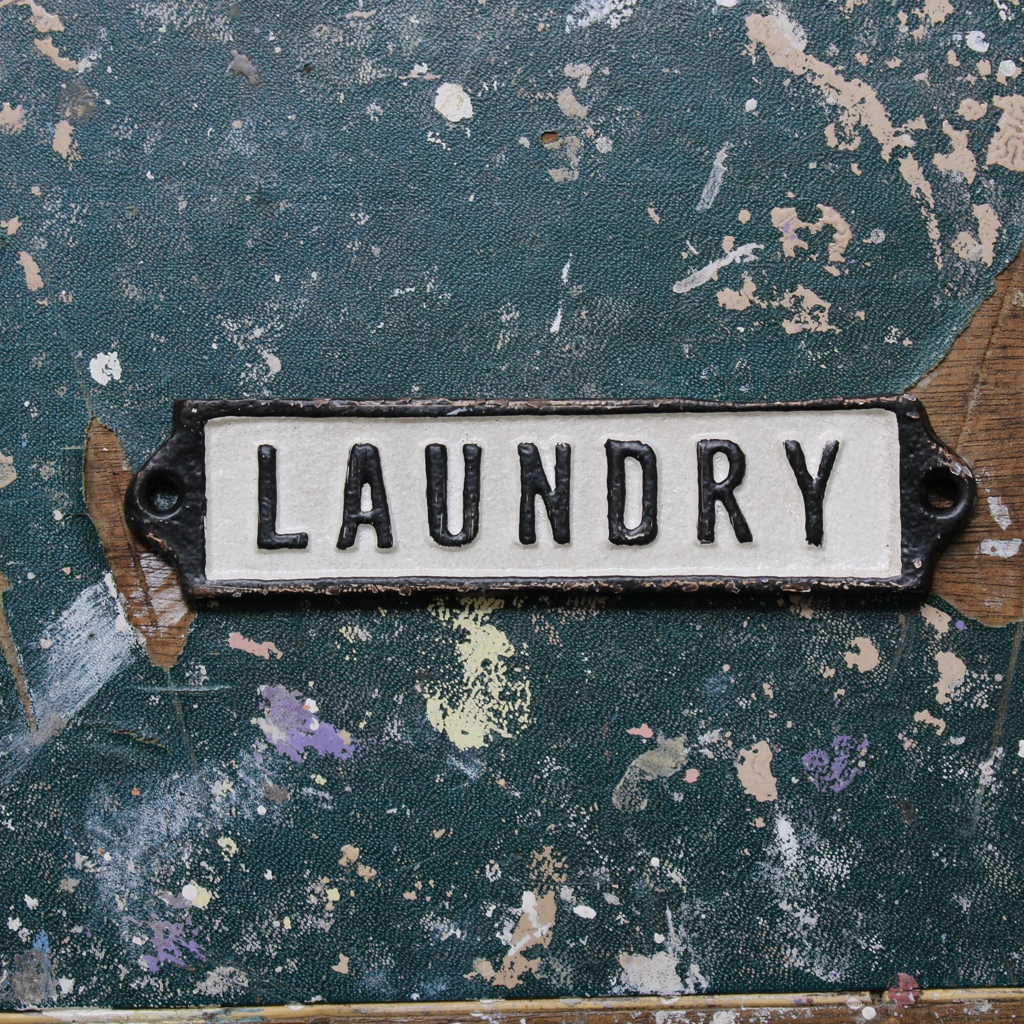 Metal laundry door plate on a vintage table top