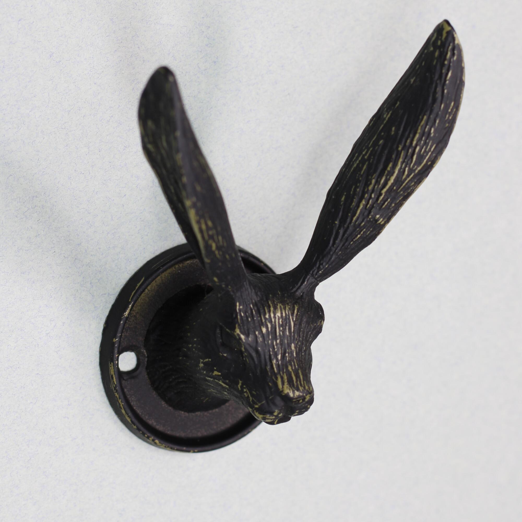 Close up of a vintage black hare head wall hook with gold highlights.