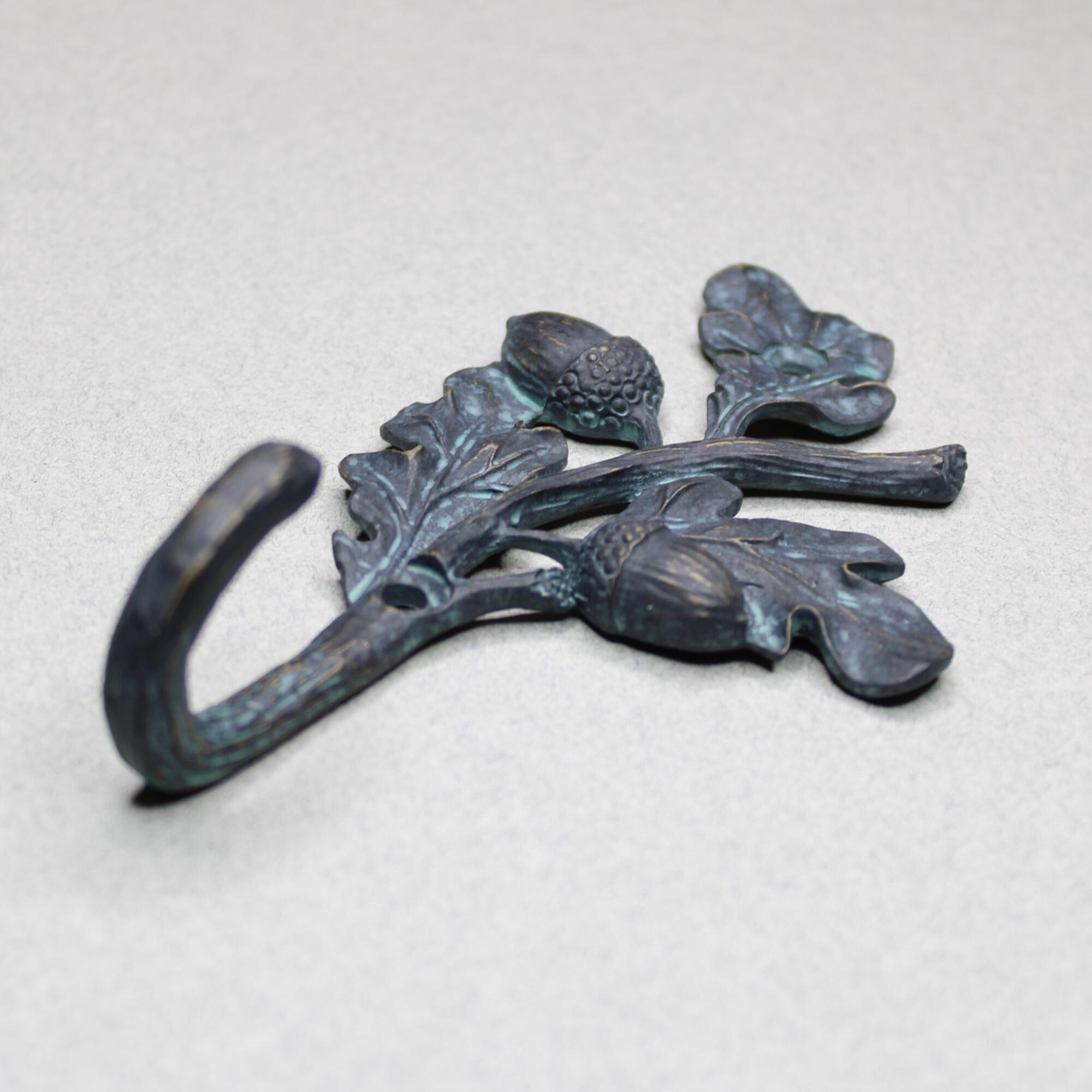 Angled view of antique verdigris oak branch wall hook for entryway organization