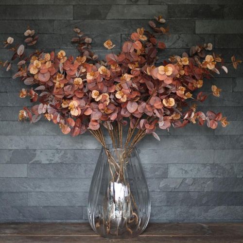 Fake eucalyptus with long stem in a large glass vase
