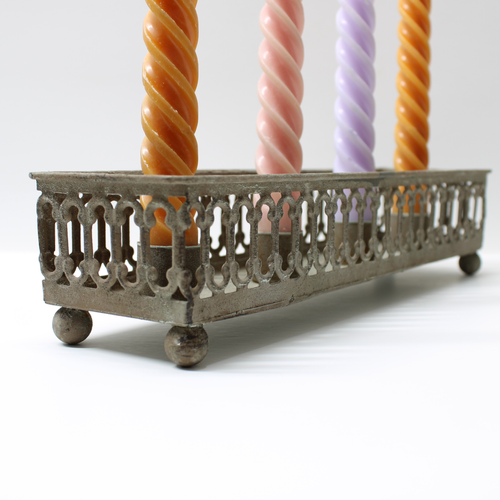 decorative metal oblong candle tray with with vintage inspired detailing holding four coloured candle sticks