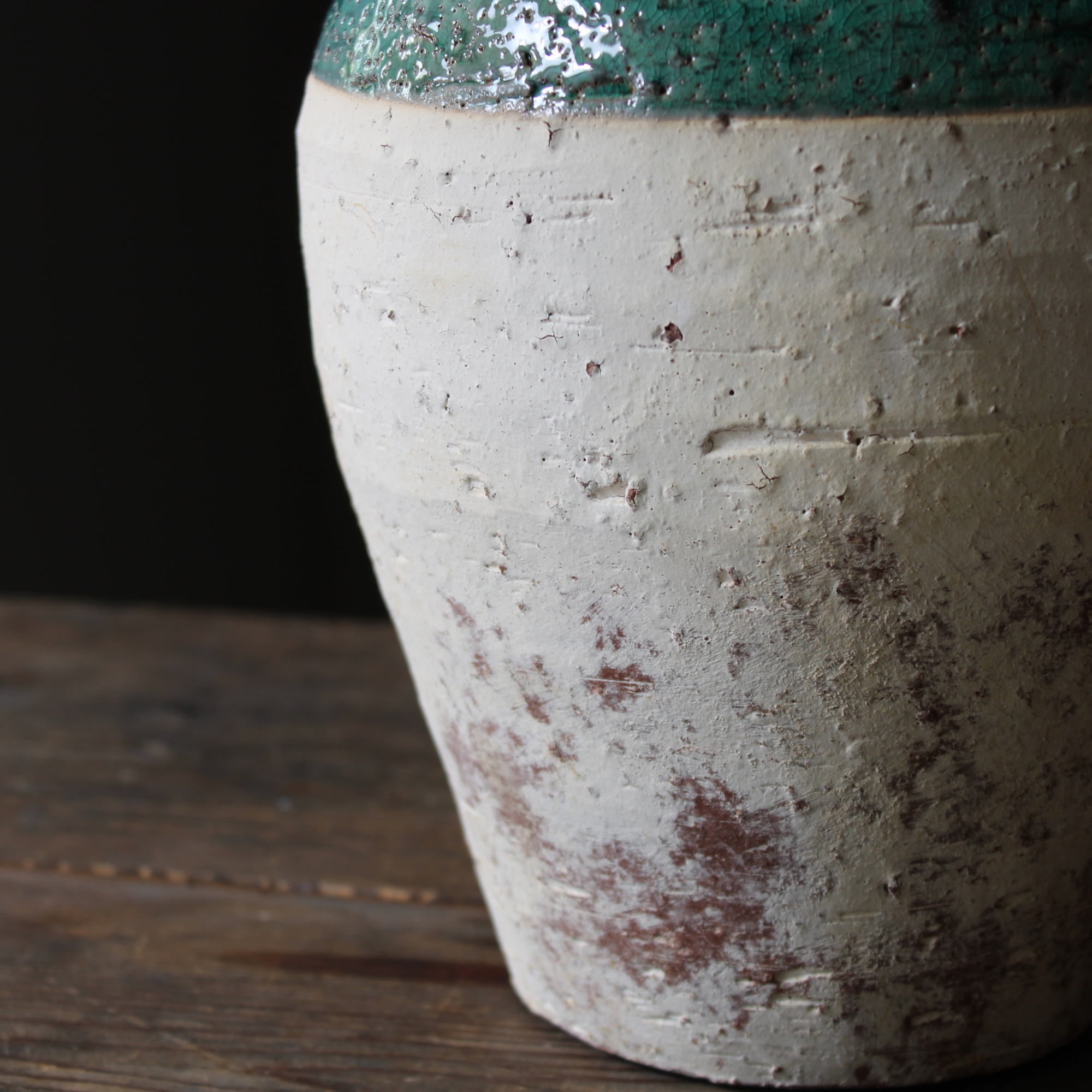 close-up of the unglazed, porous terracotta base of the rustic jug.