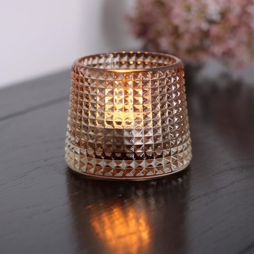 Tea light with light brown pyramid textured glass on black bedroom table