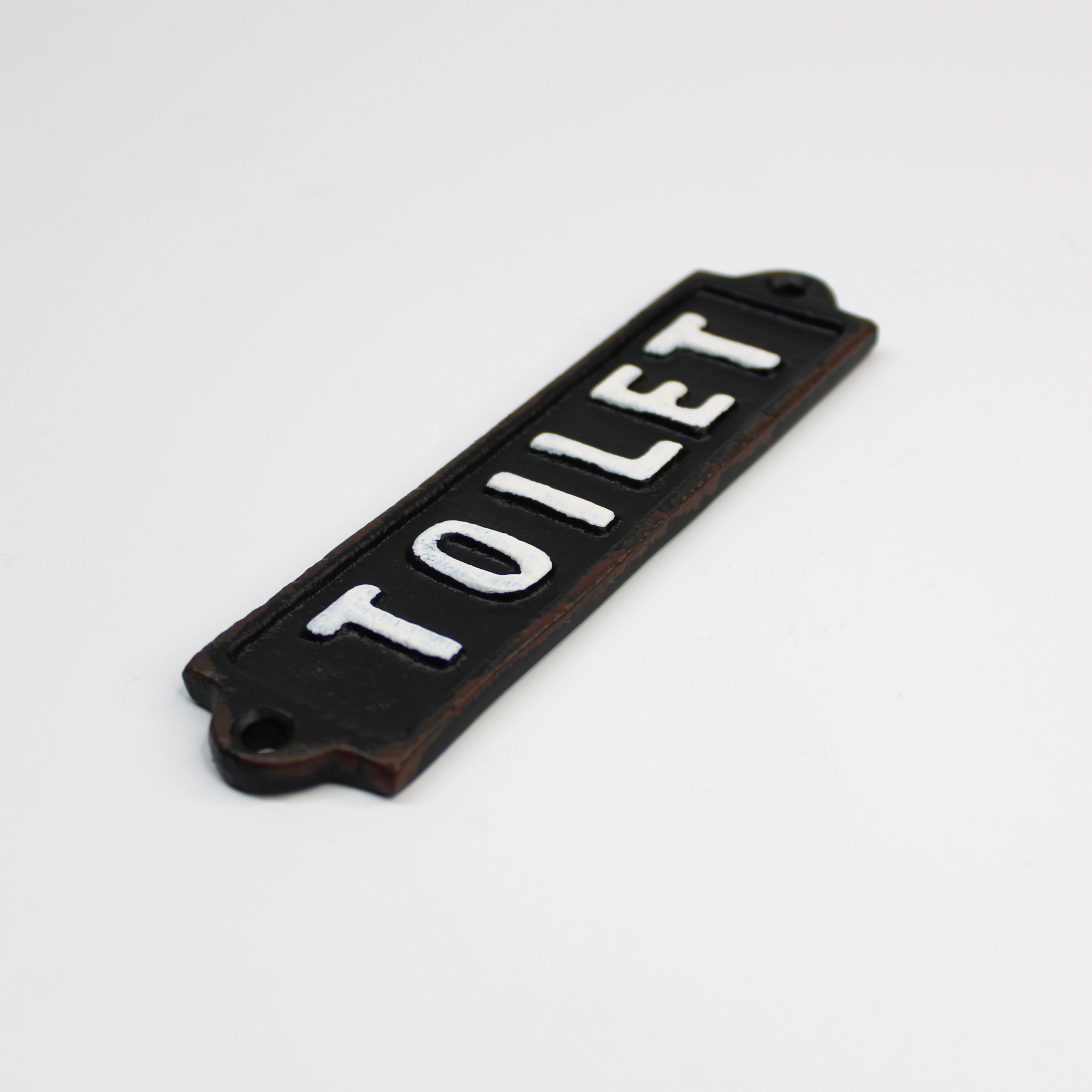 Vintage-style cast iron bathroom door plaque with a distressed black finish and bold white 'TOILET' text, suitable for farmhouse or industrial decor.