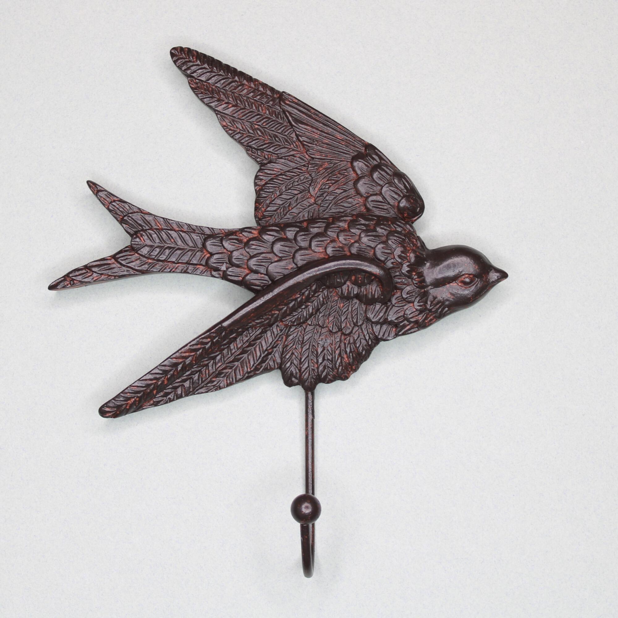 Front view of a decorative bird wall hook in a flying swallow design with a weathered bronze finish.