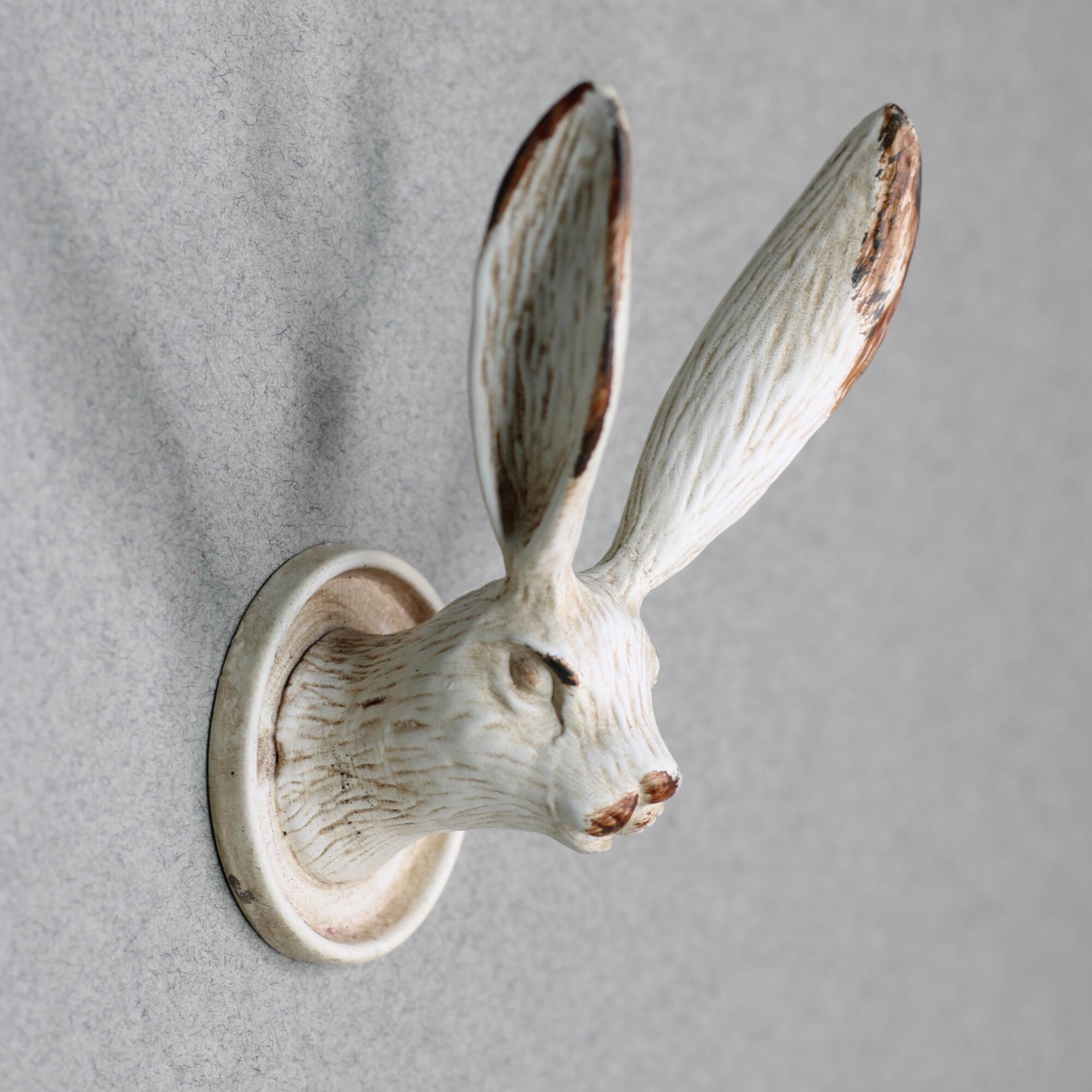 Detailed side view of a rustic rabbit head wall hook featuring long upright ears.
