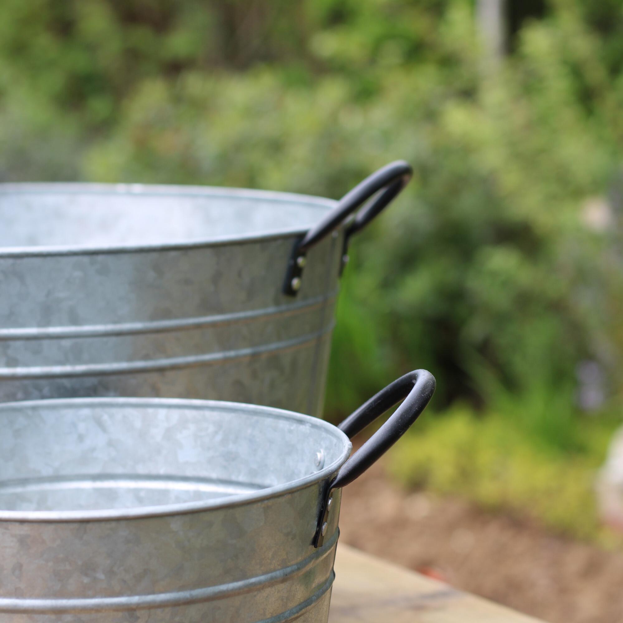 Metal garden tubs with black handles.
