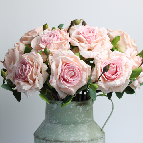 artificial pink roses arranged in a vintage milk churn