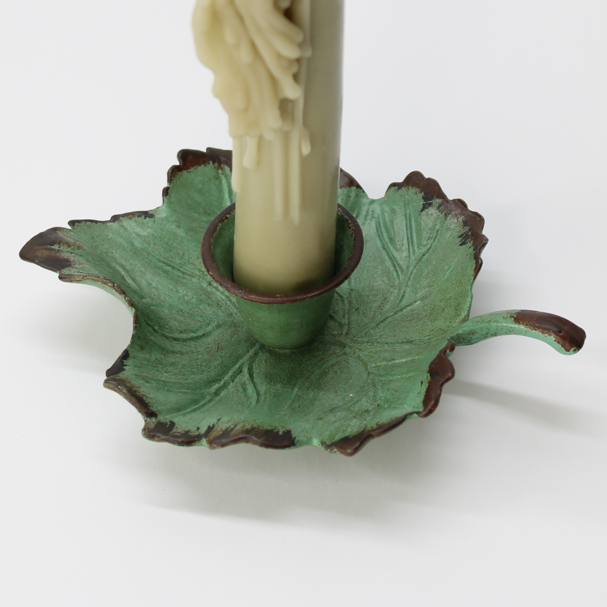 botanical-style cast iron candle holder with ivy leaf detail