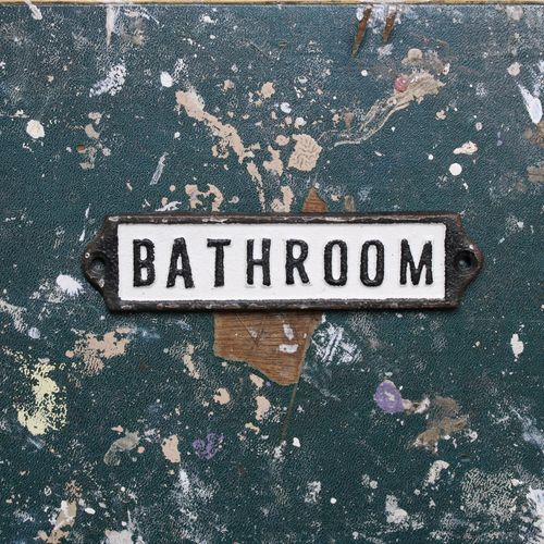 Metal bathroom wall plate on a vintage table top