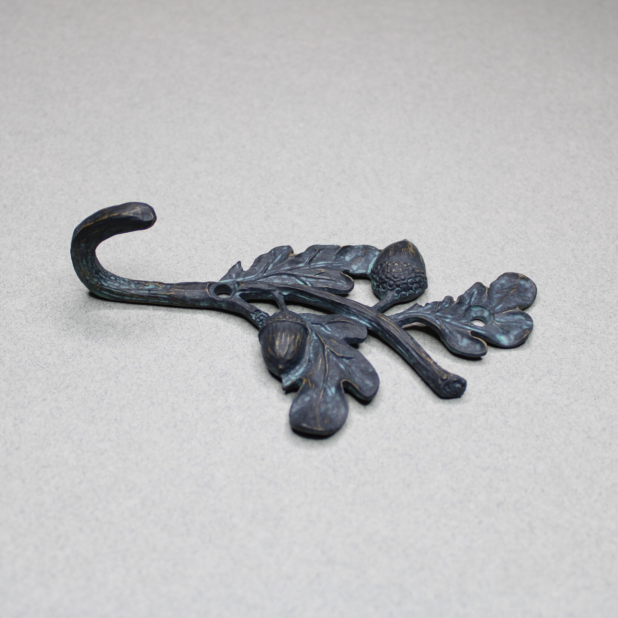 Side profile of acorn and oak leaf wall hanger showing hook curvature and depth