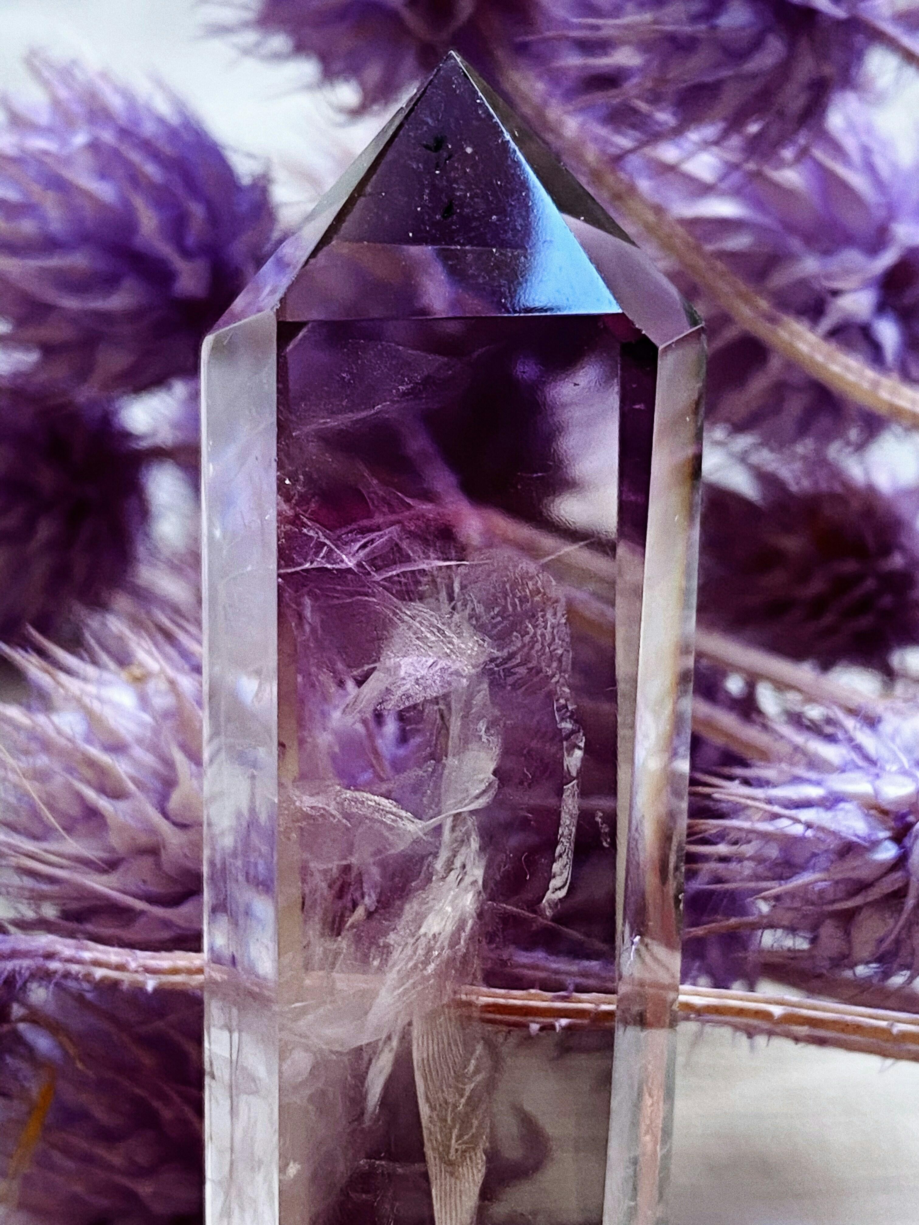 Large Amethyst on a table near a candle and other crystals