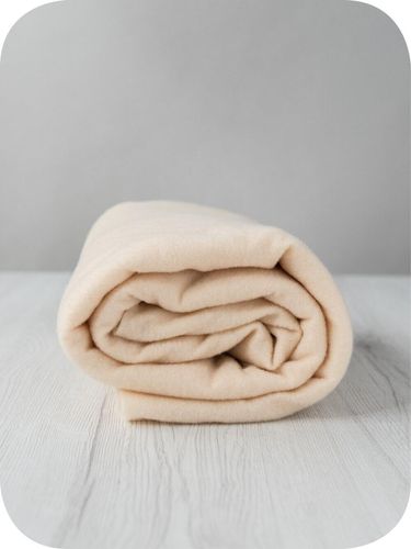 A roll of soft, cream-coloured Acacia extra fine merino wool prefelt.