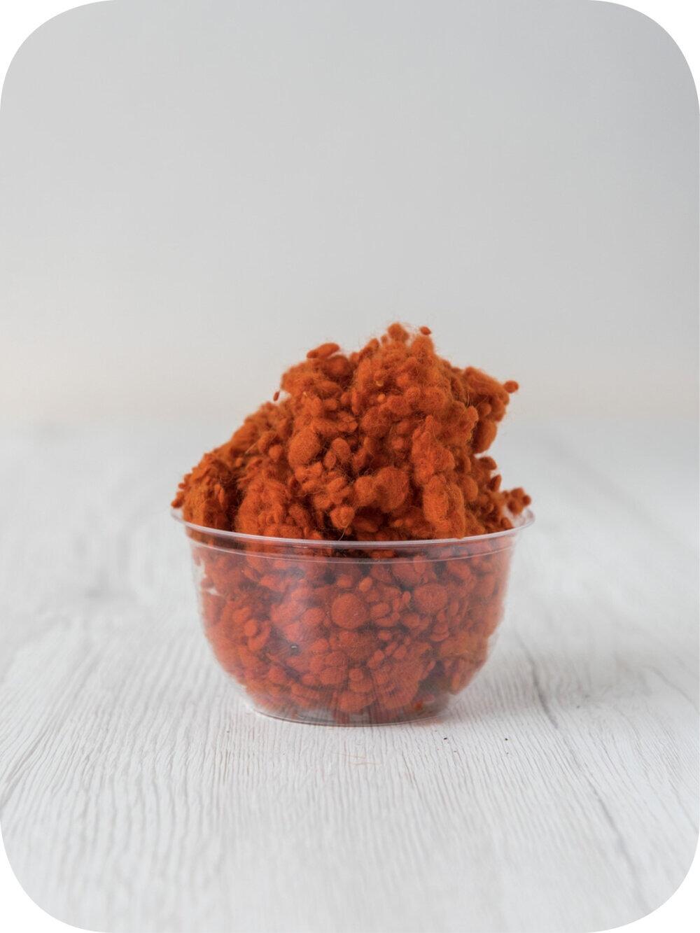 pumpkin orange wool nepps in a 5g portion for adding texture to felting and spinning projects