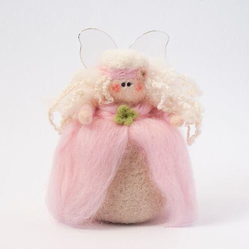 A 3D needle-felted fairy in a soft pink gown with long curly white hair, a green flower accent, and delicate wings.