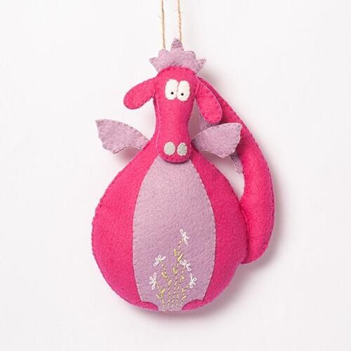 A 3D padded felt dragon named Doris with a vibrant pink body, lilac tummy and wings, and delicate white embroidered flowers on her front.