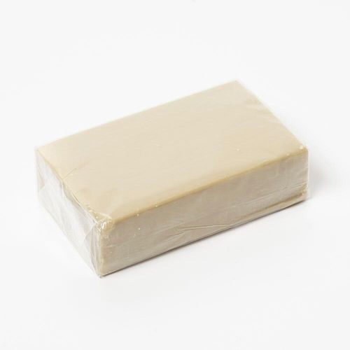 A rectangular bar of pale green natural olive oil soap for wet felting.