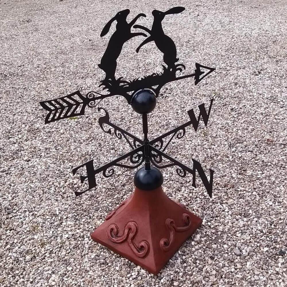 Boxing hares weathervane mounted on a square roof tile capping