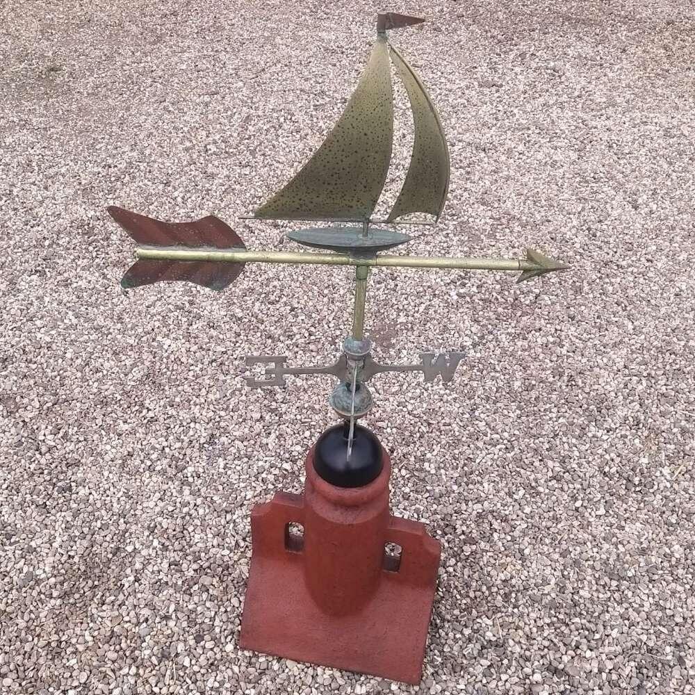 Verdigris boat weathervane fixed to a 45 degree ridge finial