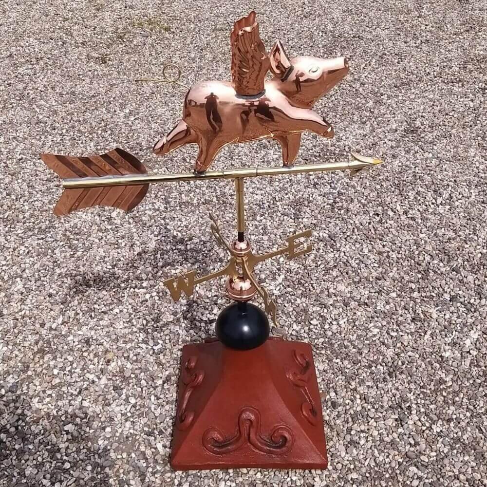 Flying pig weathervane fitted to a square roof tile capping