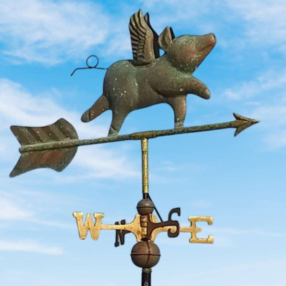 Flying pig verdigris weathervane fixed on a round ridge tile finial cap