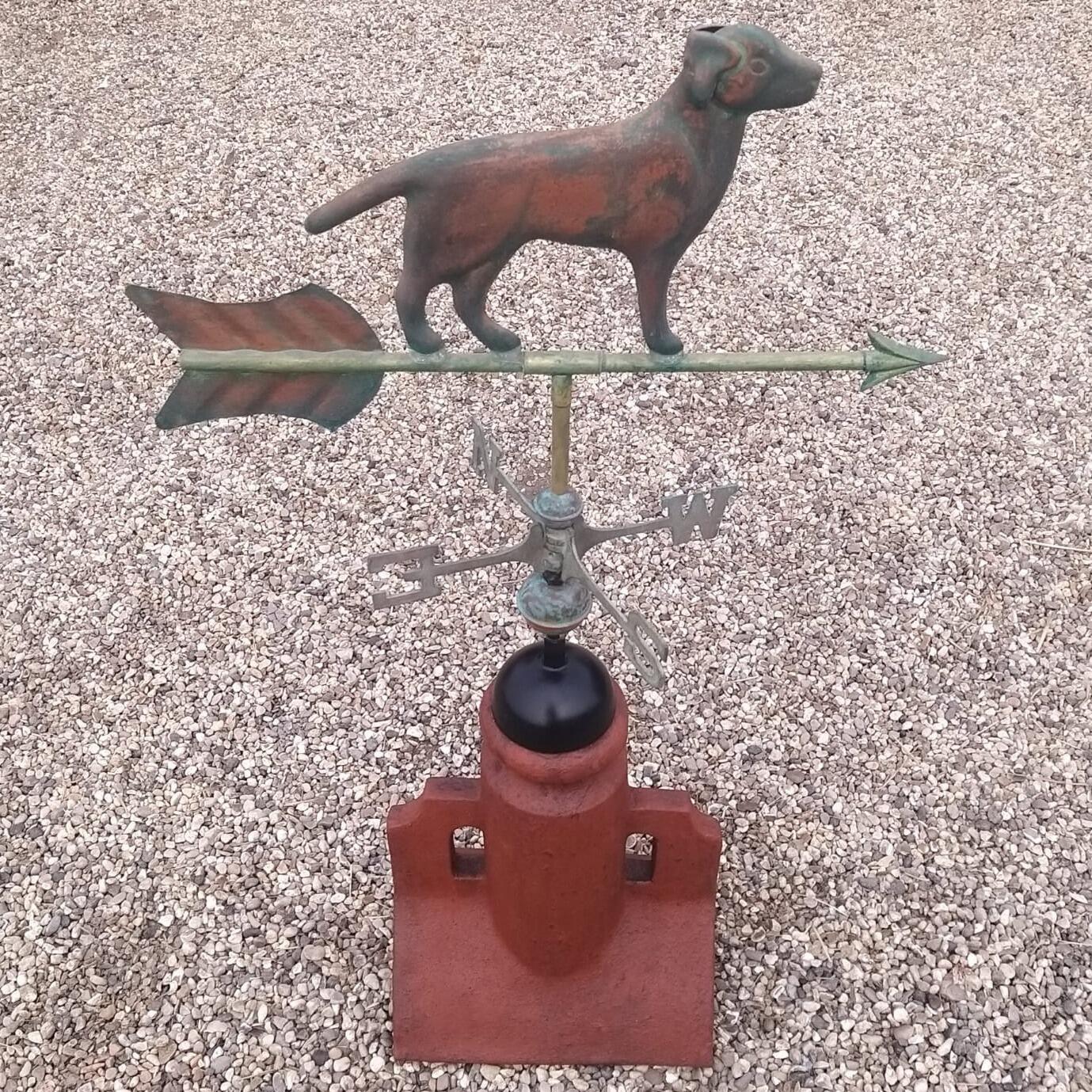 Verdigris dog weathervane fixed to an angled 45 degree ridge tile finial