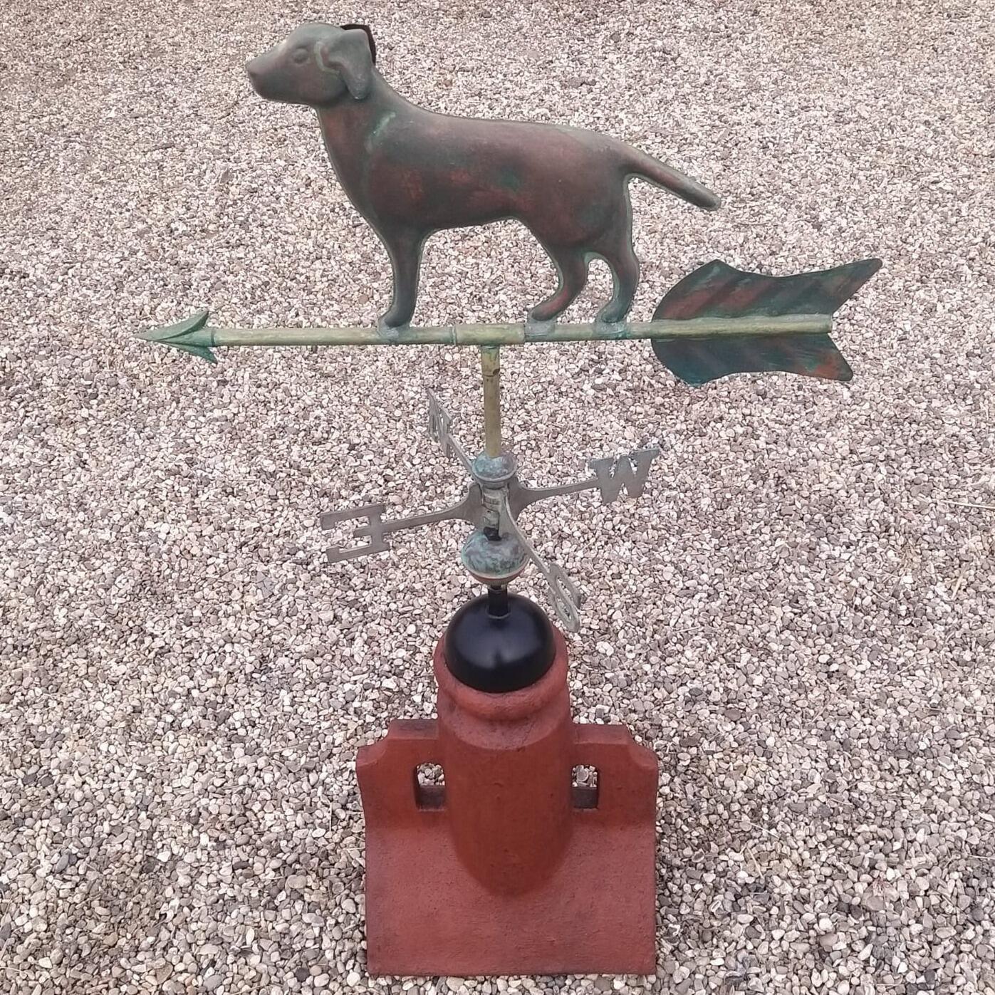 Verdigris dog weathervane fixed to an angled 45 degree ridge tile finial
