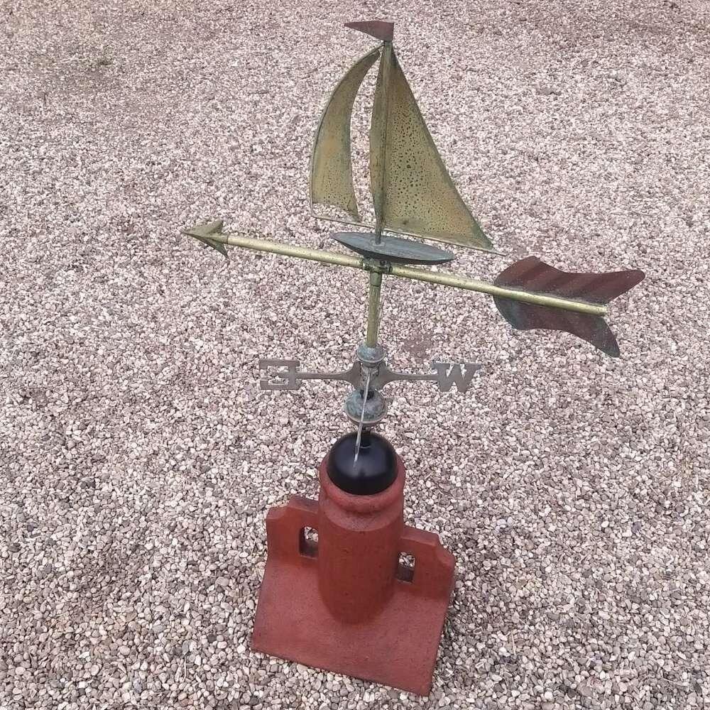 Verdigris boat weathervane fixed to a 45 degree ridge finial
